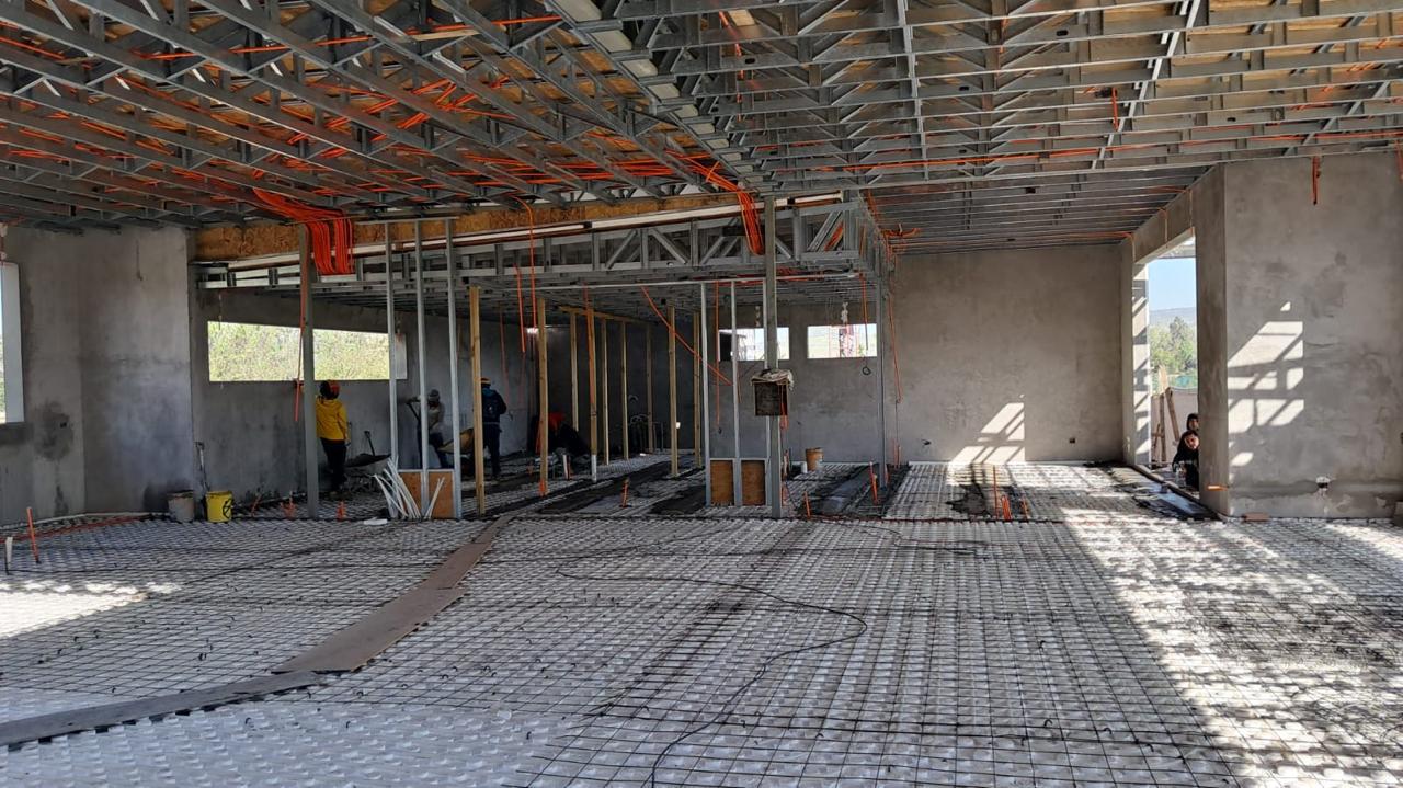 Interior de obra gruesa con estructura metálica, cerchas y losa con casetones ejecutada por Valcorp
