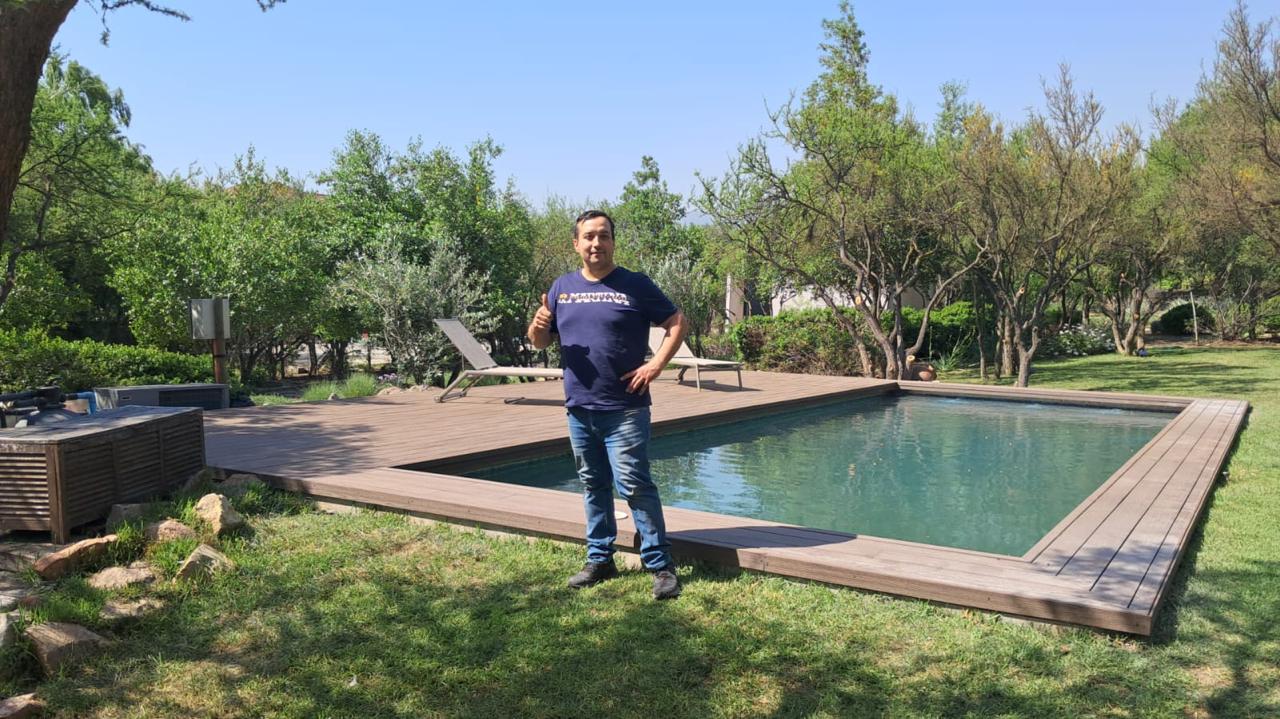 César Valencia de Valcorp junto a una piscina con deck de madera recién entregada
