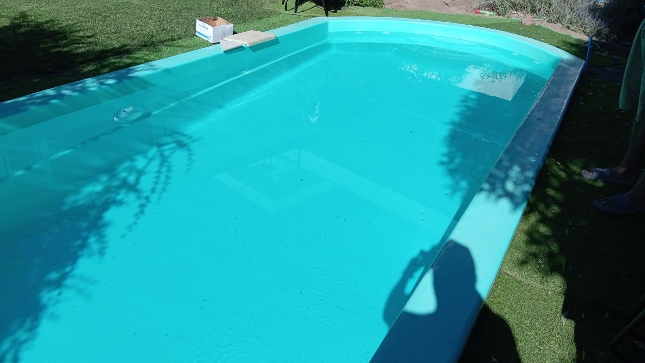 Piscina de fibra de vidrio turquesa recién instalada, en proceso de llenado